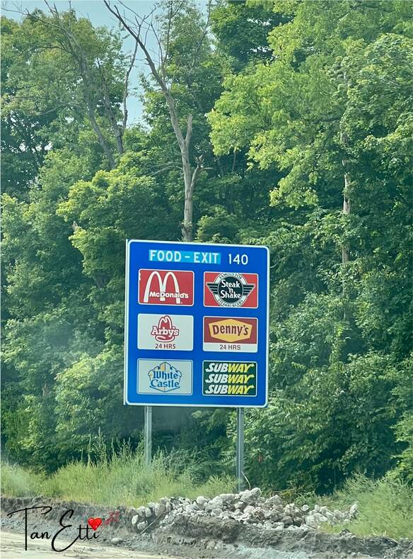 Schild mit Restaurants & Fast-Food Ketten bei der nächsten Ausfahrt